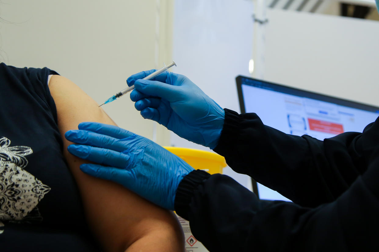 A health worker administers Pfizer Covid-19 vaccine to a woman at a vaccination center in London, England on Oct. 6, 2021. (Dinendra Haria/SOPA Images/LightRocket via Getty Images)