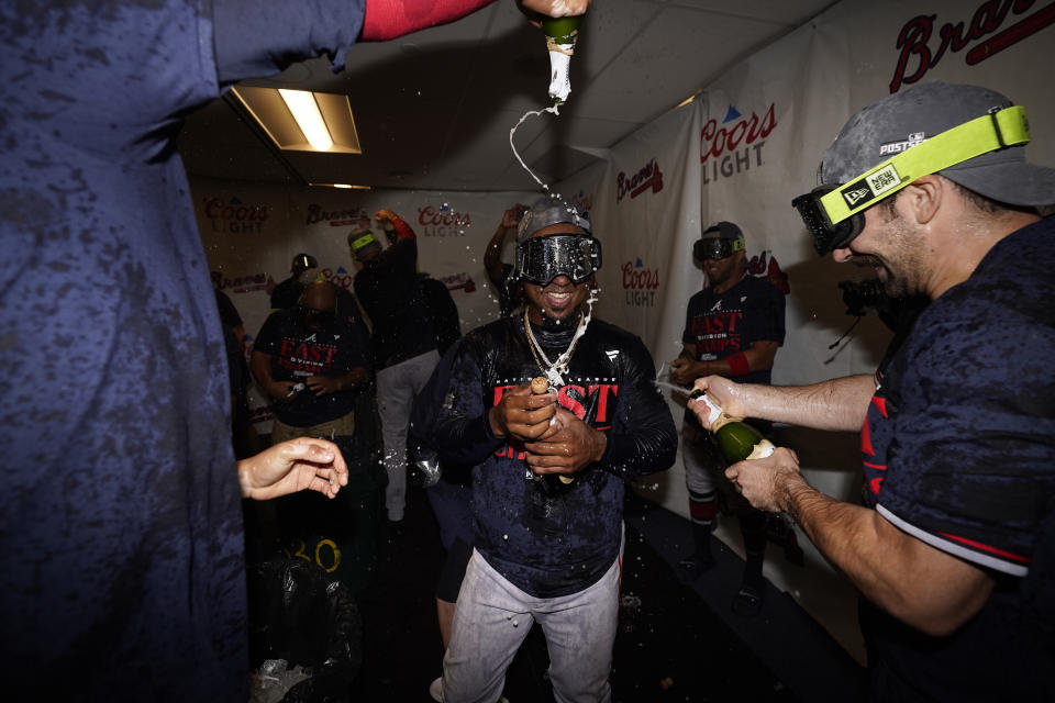 Atlanta Braves' Ozzie Albies celebrates with teammates after the Braves clinched their sixth consecutive NL East title by defeating the Philadelphia Phillies in a baseball game, Wednesday, Sept. 13, 2023, in Philadelphia. (AP Photo/Matt Slocum)