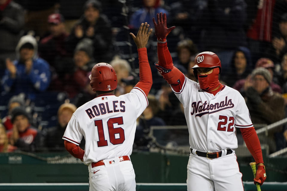 Washington Nationals' Victor Robles celebrates with Juan Soto (22) after Robles scored on a double by Cesar Hernandez during the sixth inning in the second game of a baseball doubleheader against the Arizona Diamondbacks at Nationals Park, Tuesday, April 19, 2022, in Washington. (AP Photo/Alex Brandon)