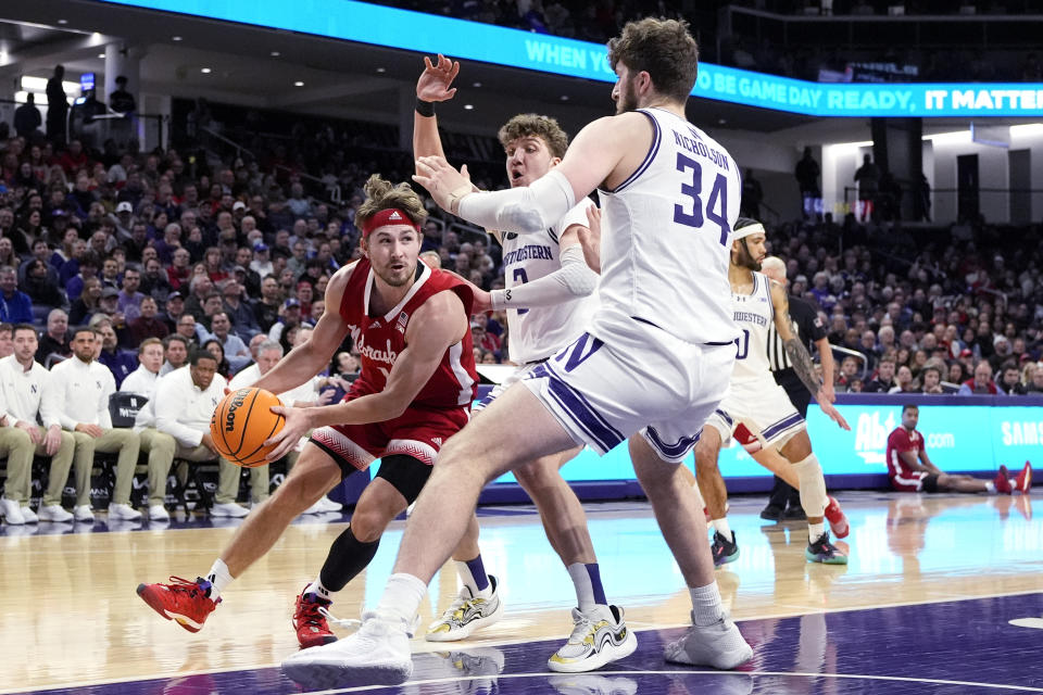 Nebraska guard Sam Hoiberg, left, drives against Northwestern center Matthew Nicholson, right, and Northwestern forward Nick Martinelli during the first half of an NCAA college basketball game in Evanston, Ill., Wednesday, Feb. 7, 2024. (AP Photo/Nam Y. Huh)