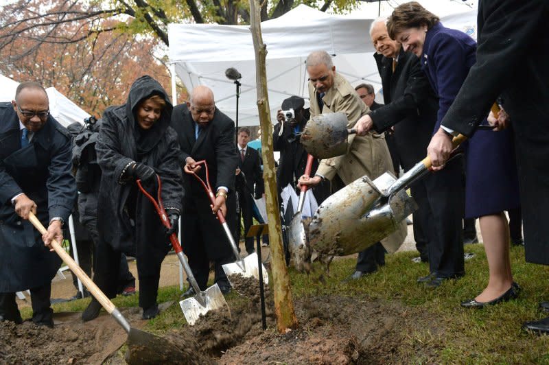 From left to right, journalist Eugene Robinson, television journalist and author Janet Langhart Cohen, Rep. John Lewis, D-Ga, Attorney General Eric Holder, Sen. Thad Cochran, R-Miss., and Sen. Susan Collins, R-Maine, participate in a planting for a memorial tree for Emmett Till, on the ground of the U.S. Capitol in Washington, D.C. on November 17, 2014. On August 28, 1955, while visiting family members in Money, Miss., 14-year-old Till was slain for supposedly flirting with a white woman four days earlier. His alleged killers were acquitted. File Photo by Kevin Dietsch/UPI
