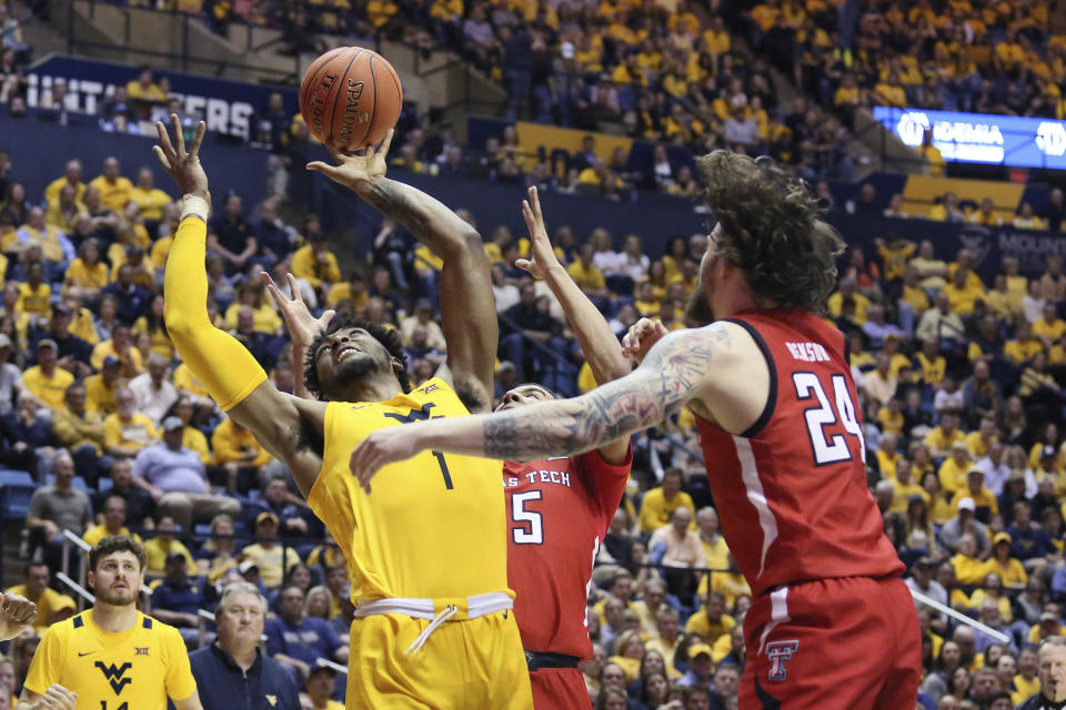 West Virginia forward Derek Culver (1) goes to shoot as he is defended by Texas Tech guards Kevin McCullar (15) and Avery Benson (24) during the second half of an NCAA college basketball game Saturday, Jan. 11, 2020, in Morgantown, W.Va. (AP Photo/Kathleen Batten)