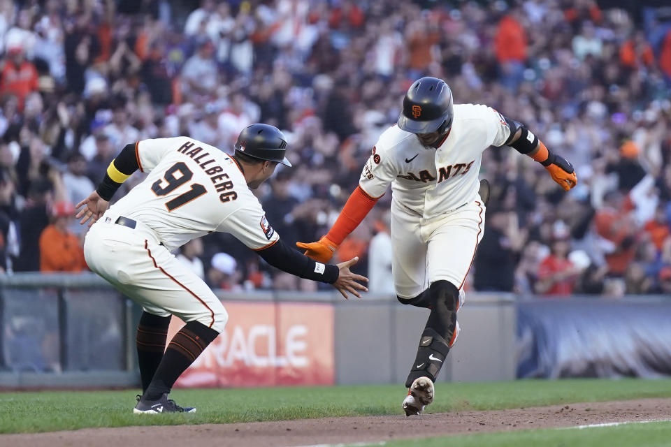 San Francisco Giants' Thairo Estrada, right, is congratulated by third base coach Mark Hallberg (91) after hitting a home run against the Colorado Rockies during the third inning of a baseball game in San Francisco, Sunday, Sept. 10, 2023. (AP Photo/Jeff Chiu)