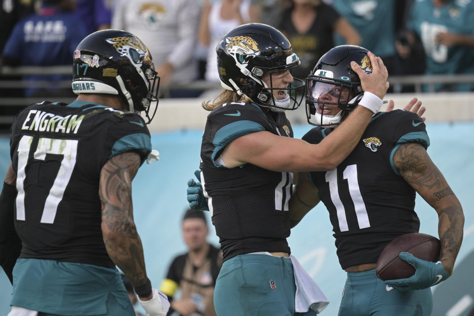 Jacksonville Jaguars wide receiver Marvin Jones Jr. (11) is congratulated by Jacksonville Jaguars quarterback Trevor Lawrence (16) after a touchdown during the second half of an NFL football game against the Baltimore Ravens, Sunday, Nov. 27, 2022, in Jacksonville, Fla. (AP Photo/Phelan M. Ebenhack)