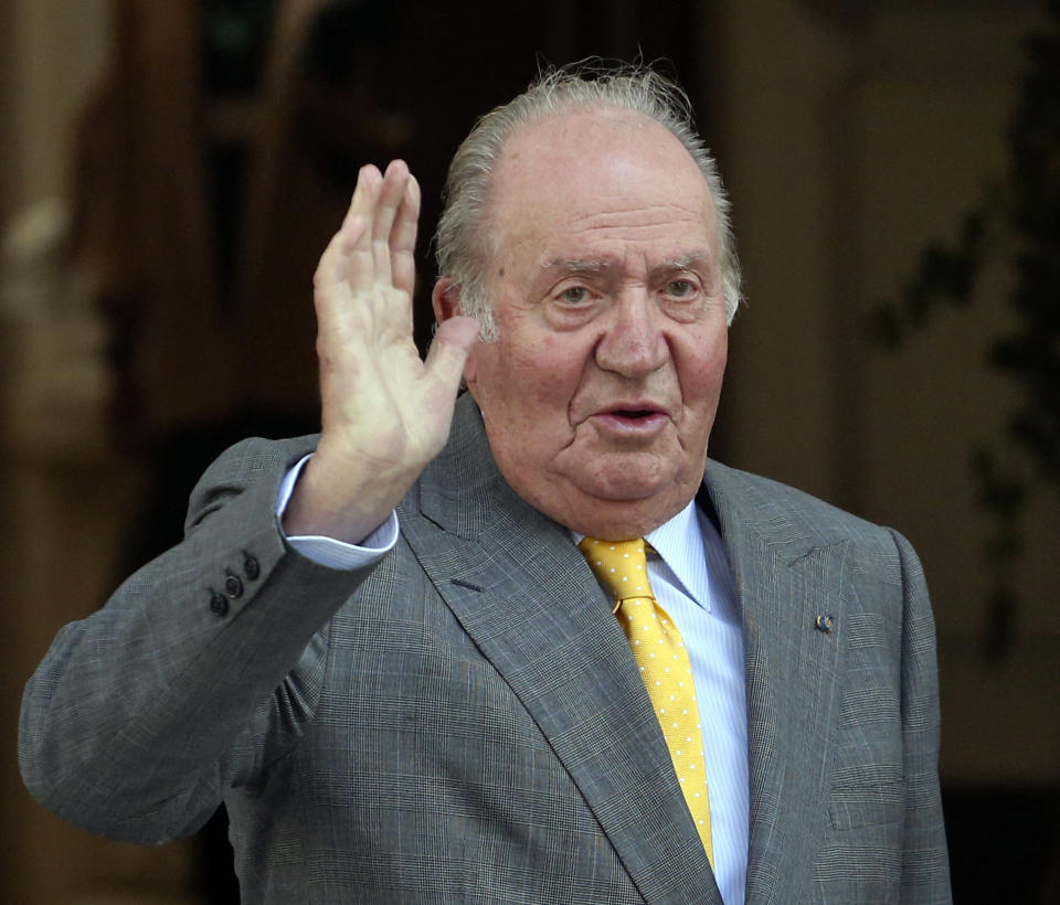 FILE - In this March 10, 2018, file photo, Spain's emeritus King Juan Carlos waves upon his arrival to the Academia Diplomatica de Chile, in Santiago where he met with President-elect Sebastian Pinera. Spain’s former King Juan Carlos abdicated at age 76 to King Felipe in 2014 amid scandals, and the succession laws to allow it were changed in just two weeks. (AP Photo/Esteban Felix, File)