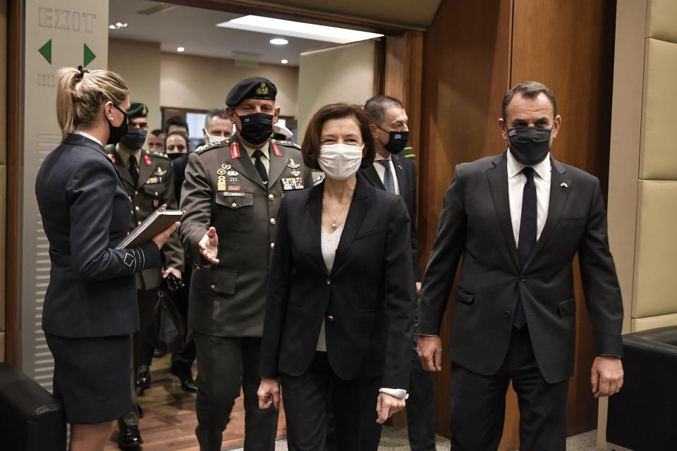 French Defense Minister Florence Parly, left, and his Greek counterpart Nikos Panagiotopoulos, right, arrive for a meeting in Athens, Monday, Jan. 25, 2021. Greece is due to sign a 2.3 billion euro ($2.8 billion) deal with France Monday to purchase 18 Rafale fighter jets to address tension with neighbor Turkey. (Louisa Gouliamaki/Pool via AP)