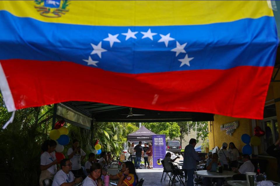 Members of the Venezuelan exile community gather in the shade at the local eatery Arepazo in Doral, Florida, on Sunday, July 28, 2024, in Miami, Florida, to monitor the election in their homeland.