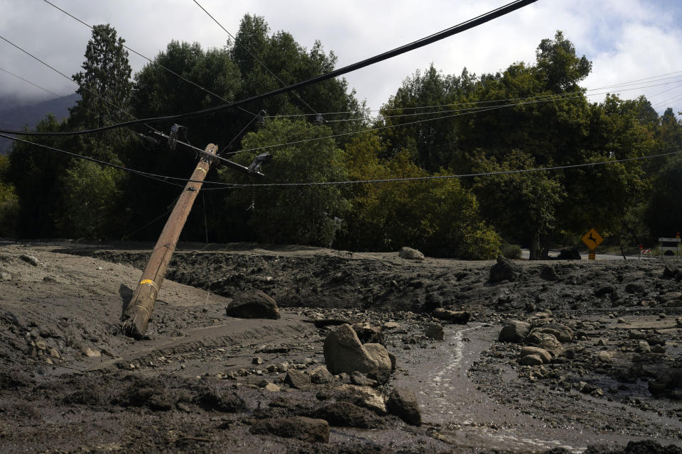 Electric poles are seen half-fallen in the aftermath of a mudslide Tuesday, Sept. 13, 2022, in Oak Glen, Calif. Cleanup efforts and damage assessments are underway east of Los Angeles after heavy rains unleashed mudslides in a mountain area scorched by a wildfire two years ago. (AP Photo/Marcio Jose Sanchez)