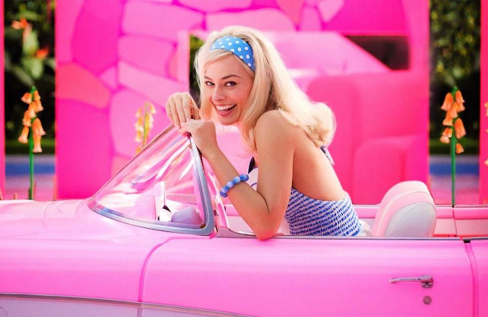 Margot Robbie as Barbie in a pink convertible