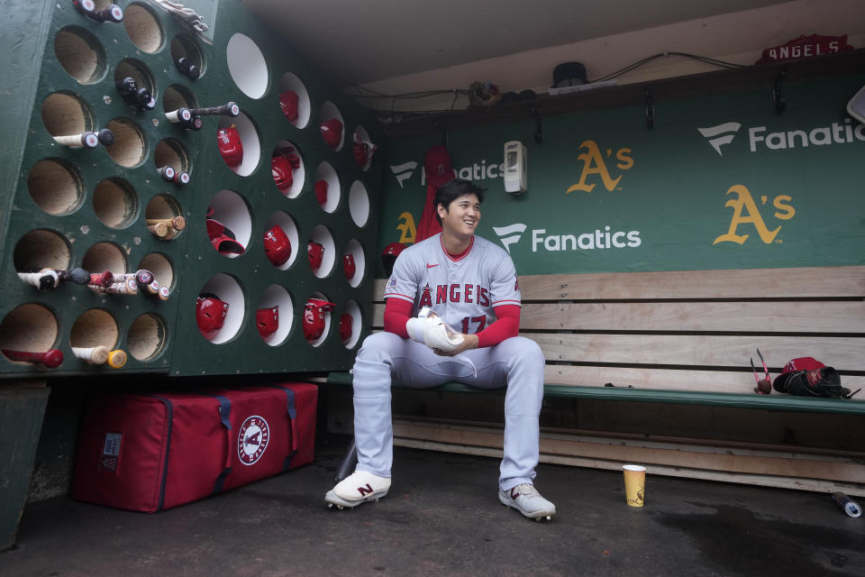 FILE - Los Angeles Angels' Shohei Ohtani sits in the dugout before the team's baseball game against the Oakland Athletics in Oakland, Calif., Sept. 2, 2023. Ohtani likely has the AL MVP race wrapped up. His two-way prowess was derailed by a torn elbow ligament in August, but for five months, he treated baseball fans to one of the most impressive performances in MLB history. (AP Photo/Jeff Chiu, File)