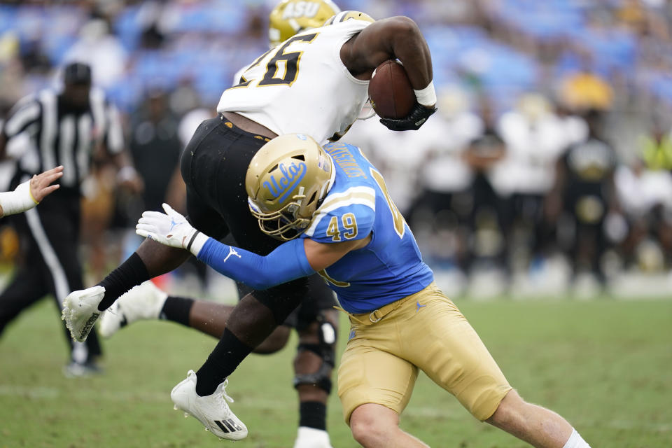 UCLA linebacker Carson Schwesinger (49) tackles Alabama State running back Marcus Harris II (26) during the second half of an NCAA college football game in Pasadena, Calif., Saturday, Sept. 10, 2022. (AP Photo/Ashley Landis)