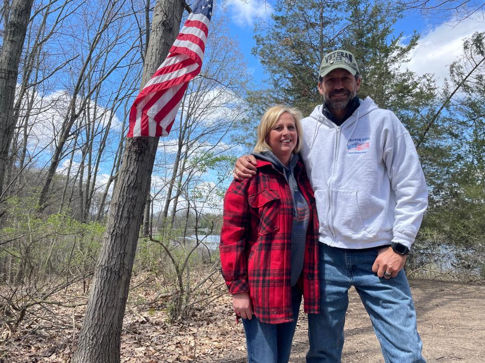 Janna and Jeff Yeakey pose for a photo near Gut Lake in Hamburg Township, where they plan to install veterans retreat Freedom River.