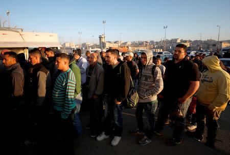 Palestinians working in Israel wait to cross through Israeli Qalandiya checkpoint near the West Bank city of Ramallah April 25, 2017. REUTERS/Mohamad Torokman