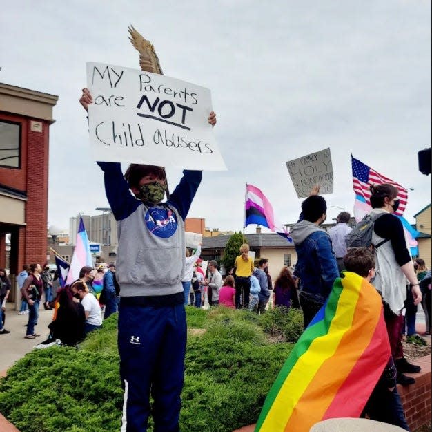 An activist protests a Texas effort to label efforts to obtain gender-affirming care as "child abuse." Governmental action and legislation in Texas and other states has led to activism by transgender people along with feelings ranging from fear to anger.