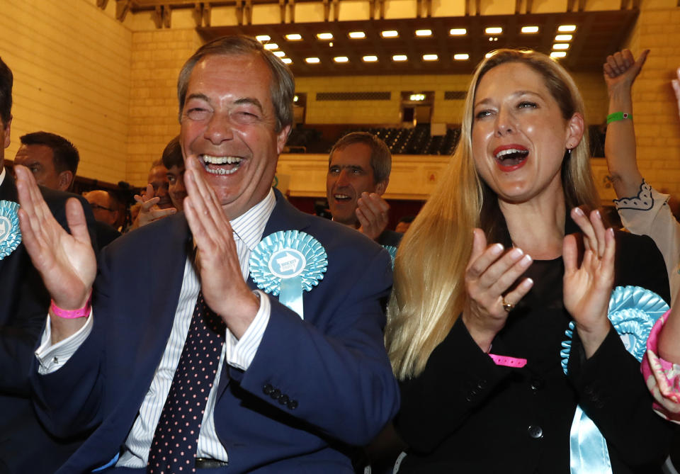 Brexit Party leader Nigel Farage, left, reacts as results are announced at the counting center for the European Elections for the South East England region, in Southampton, England, Sunday, May 26, 2019. (AP Photo/Alastair Grant)