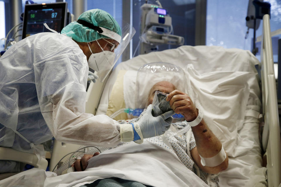 Medics tend to a COVID-19 patient at the intensive care unit of Casal Palocco hospital in Rome Tuesday, Oct. 20, 2020. The new surge of cases requiring hospitalization is causing worries in the Country that suffered the second highest toll in Europe during the Spring, as 10,874 new cases and 89 victims were registered today. (Cecilia Fabiano/LaPresse via AP)