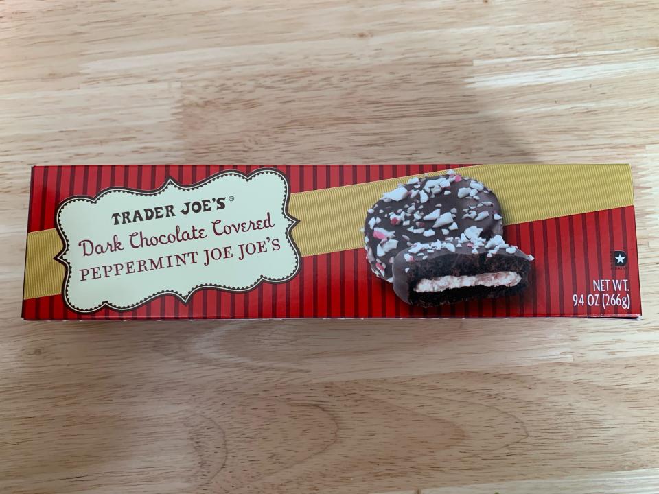 red and yellow box of trader joes dark chocolate covered peppermint joe joes on wooden table