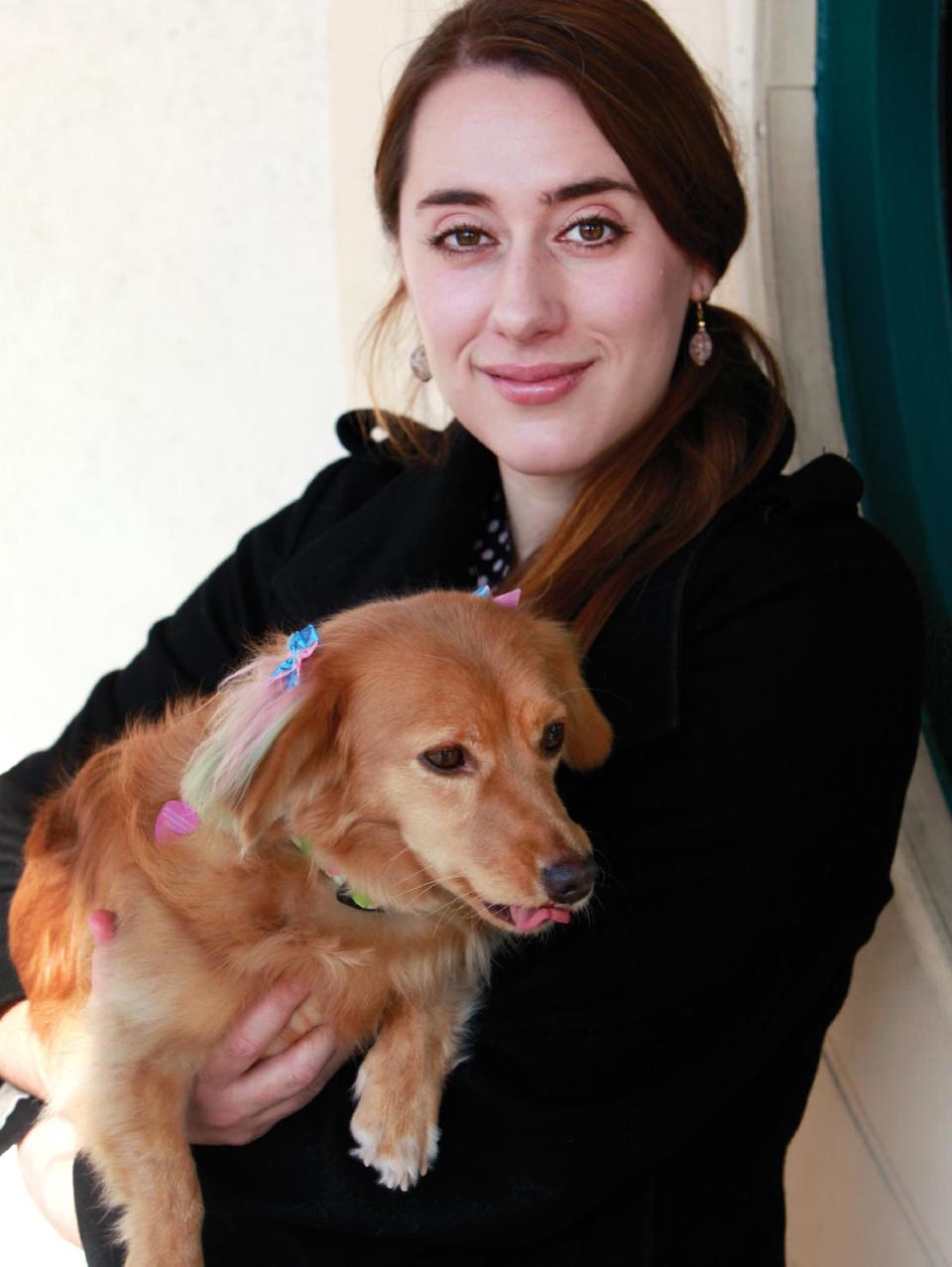 In this Friday, Dec. 13, 2013, photo, Sasha Sinnott holds her dog, a 2 year old dachshund mix, Sugarplum, after a chalking at the PetSmart in Culver City, Calif. Sugarplum went into the salon as a reddish-blonde dachshund mix and came out with pink and green ears, a rainbow tail and a bow in her fur. “It's like having a little unicorn creature," said attorney Sinnott of Pasadena, who was nearly giddy about her dog’s redesign. (AP Photo/Richard Vogel)