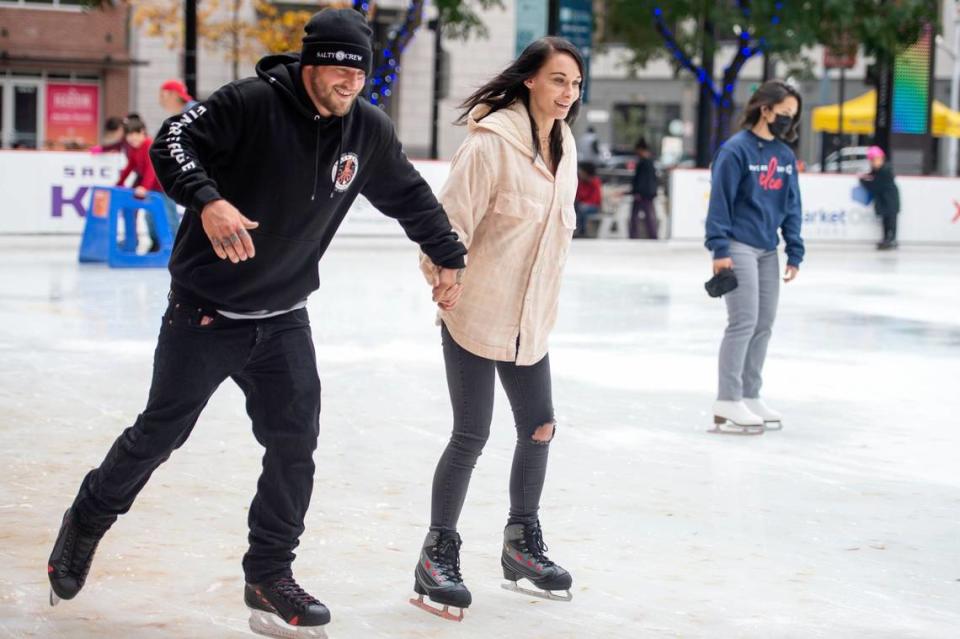 James Hubbard and Taylor Haendle, visiting from Yuba County, hold hands while taking laps around the rink at the Downtown Sacramento Ice Rink on K Street in 2021.