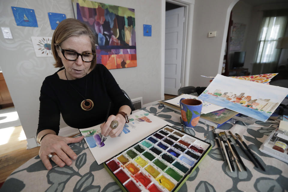 In this Jan. 8, 2020, photo Marian Nixon paints at her home in Chicago. Nixon finds its easier for her prints, clothes and sketch books to be seen on Amazon rather than on her own website. But selling online presents challenges that can be hard, even impossible to overcome. She gets good reviews for her designs, but she's had bad reviews when something has gone wrong with shipping, which is out of her control. (AP Photo/Nam Y. Huh)