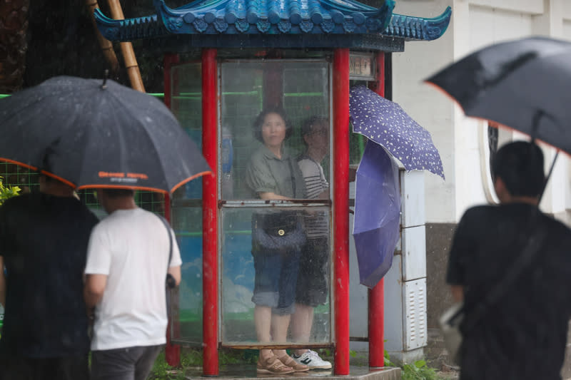 台北午後大雷雨（1） 中央氣象署24日下午發布台北市為大雷雨警戒區域。 圖為中正區午後下起滂沱大雨，遊客到電話亭內躲 雨。 中央社記者吳家昇攝  113年6月24日 