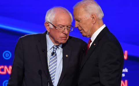 Democratic presidential hopefuls Vermont Senator Bernie Sanders (L) and former US Vice President Joe Biden chat at the end of the fourth Democratic primary debate  - Credit: AFP