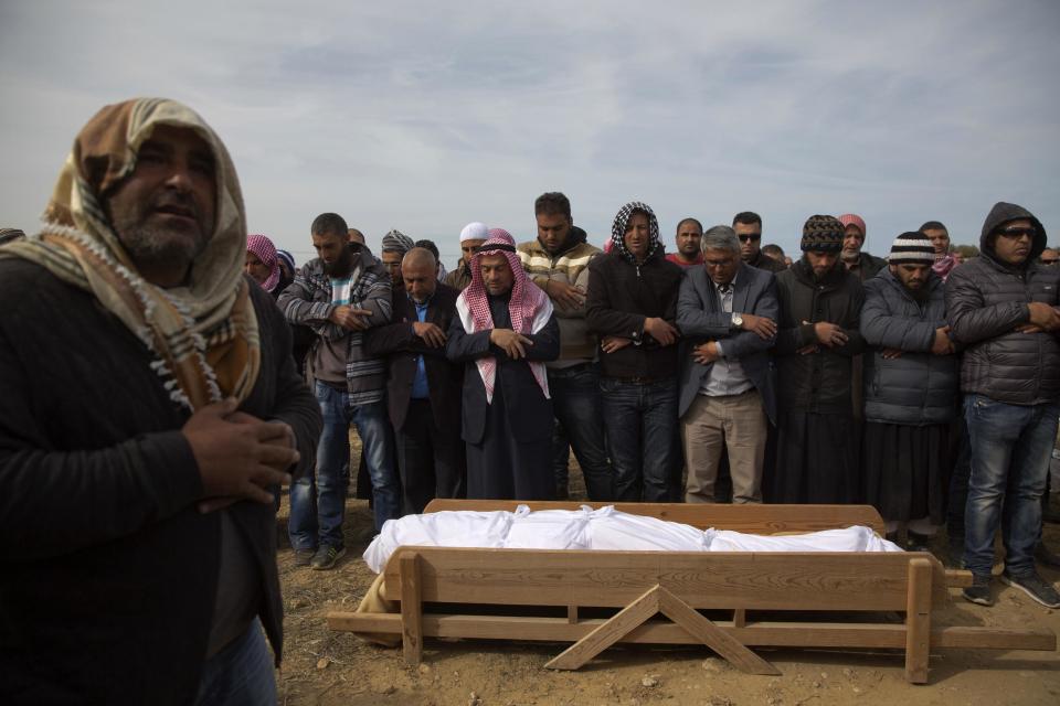 Bedouin men pray by the body of Yaakub Abu al-Qiyan during his funeral near the Bedouin village of Umm al-Hiran, Israel, Tuesday, Jan. 24, 2017. On Wednesday last week Israeli police said al-Qiyan, an Israeli Arab rammed his vehicle into a group of police officers, killing one of them before he was shot dead during clashes in southern Israel over a court-ordered operation to demolish illegally built homes. (AP Photo/Ariel Schalit)