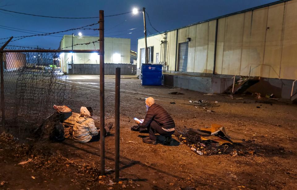 Trace Karpe interviews a woman early Thursday behind a group of buildings in northwest Oklahoma City during the Point-In-Time survey.