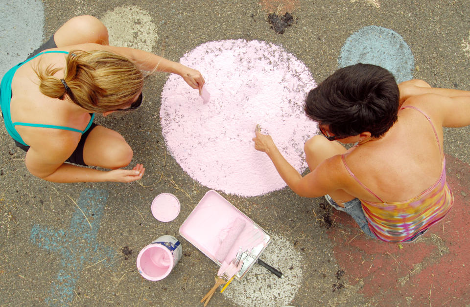 DETROIT, MI - JUNE 16: Shelly Vivano of Grand Rapids, MI (L) and Sherri Baughman of Ann Arbor, MI put a fresh coat of paint on a playground during Foster The People, Foster The Future: Do Good Project at Heidelberg Project on June 16, 2012 in Detroit, Michigan. (Photo by Paul Warner/Getty Images)