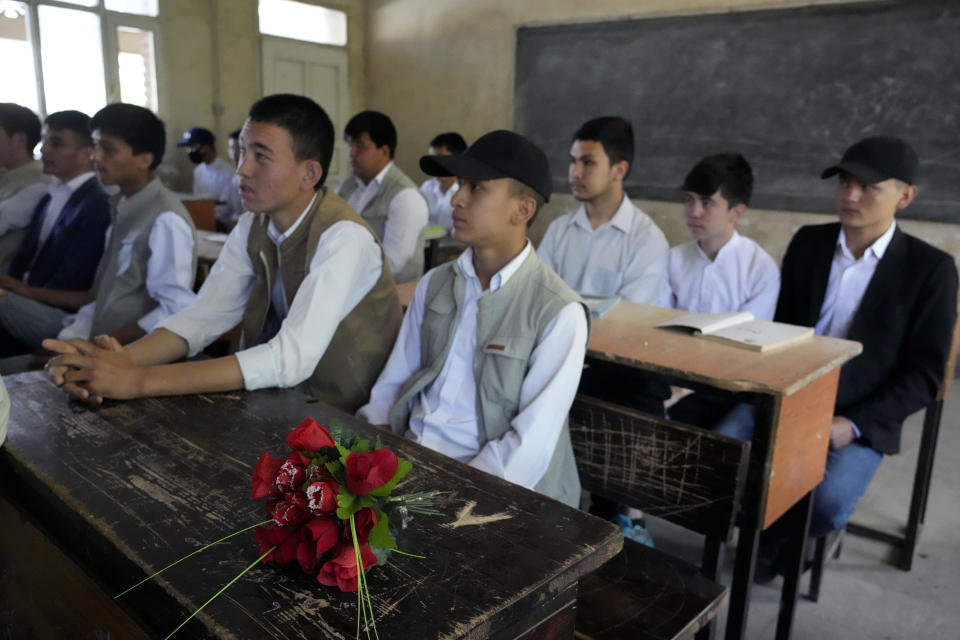 A bouquet of flowers is placed as a tribute on the desk of 19-year-old Parviz Noori who was killed on Tuesday's explosion in front of his school, in Kabul, Afghanistan, Saturday, April 23, 2022. On Saturday, the Abdul Rahim Shaheed School, which was among the IS-K targets in the Tuesday attacks, re-opened. The school's principal handed each student a pen and a flower as they began classes on Saturday. (AP Photo/Ebrahim Noroozi)