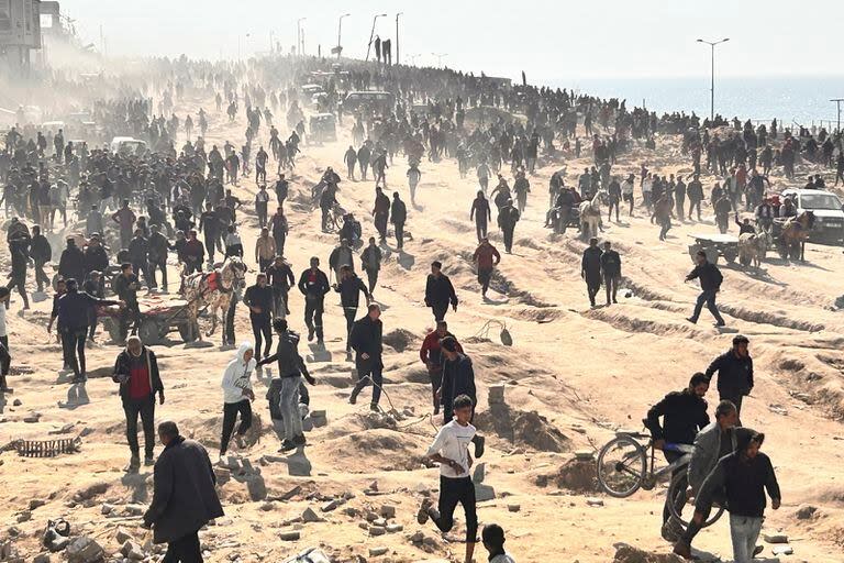 Palestinos esperan a recibir ayuda humanitaria en una playa en Ciudad de Gaza, en la Franja de Gaza, el domingo 25 de febrero de 2024. (AP Foto/Mahmoud Essa)