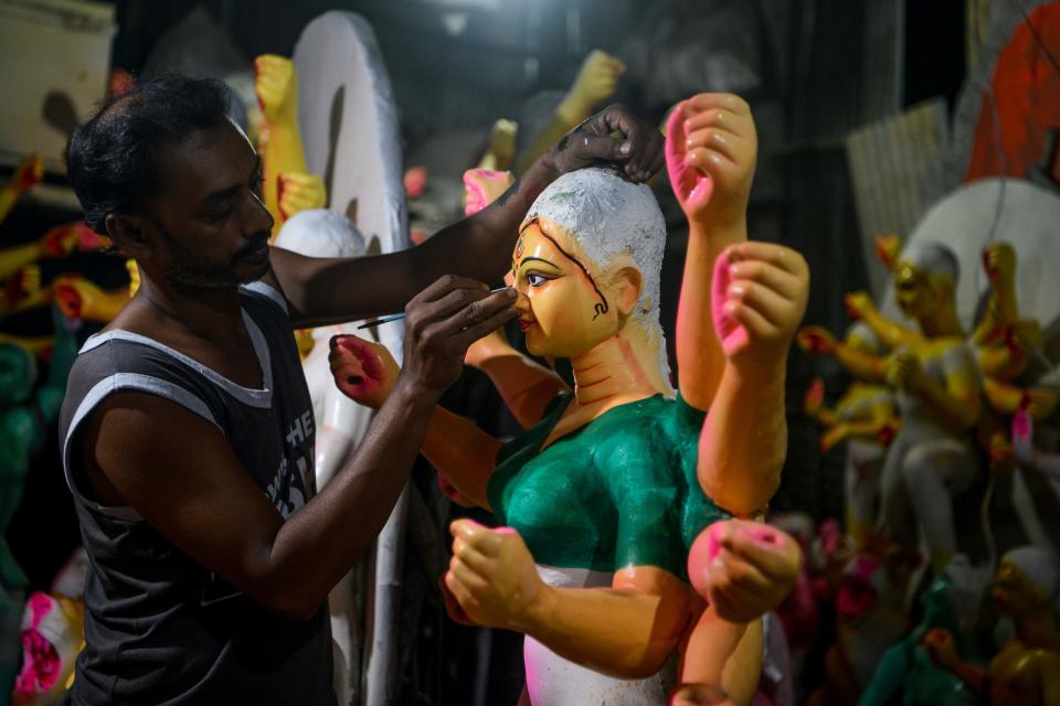 An artisan works on clay sculptures depicting Hindu goddess Durga at a workshop, ahead of the upcoming 'Durga Puja' festival, in Siliguri on October 9, 2020. (Photo by Diptendu DUTTA / AFP) (Photo by DIPTENDU DUTTA/AFP via Getty Images)