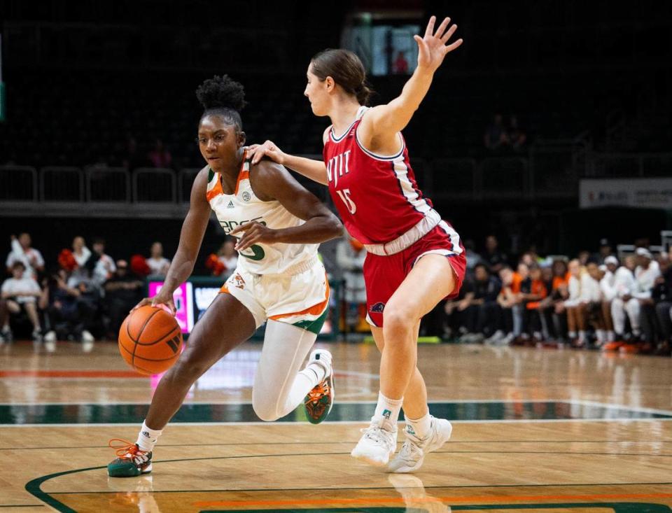 Miami Hurricanes Jaida Patrick (5) dribbles around NJIT’s Madilyn Dogs (15) during the first quarter of a game on Sunday, Dec. 3, 2023, at the Watsco Center in Coral Gables.