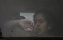 En esta imagen del lunes 27 de mayo de 2019, una mujer migrante mira por la ventana de un autobús que la lleva con otros migrantes al centro de detención Siglo XXI en Tapachula, en el estado mexicano de Chiapas. (AP Foto/Marco Ugarte)