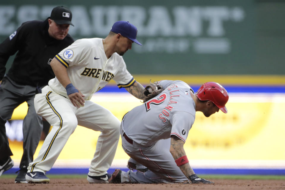 Cincinnati Reds' Nick Castellanos (2) steals second base past the tag of Milwaukee Brewers' Jace Peterson, center, during the second inning of a baseball game Monday, June 14, 2021, in Milwaukee. (AP Photo/Aaron Gash)