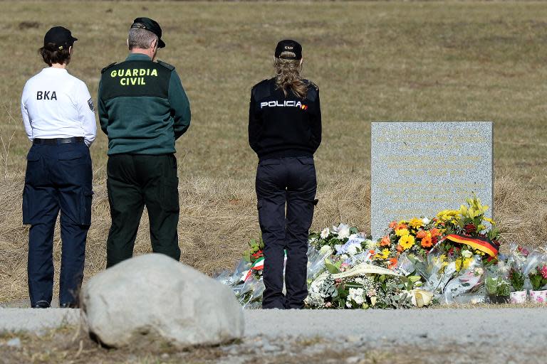 German and Spanish police officers pay tribute to the victims of the Germanwings plane crash at a memorial in Le Vernet on March 27, 2015