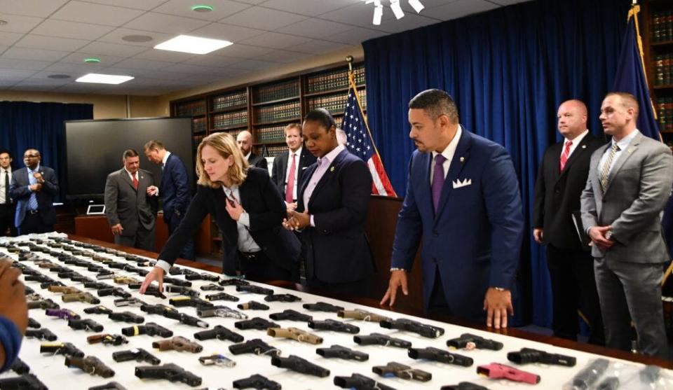 Investigators with the Queens County District Attorney's office display guns they say were sold illegally at Knoxville gun shows.