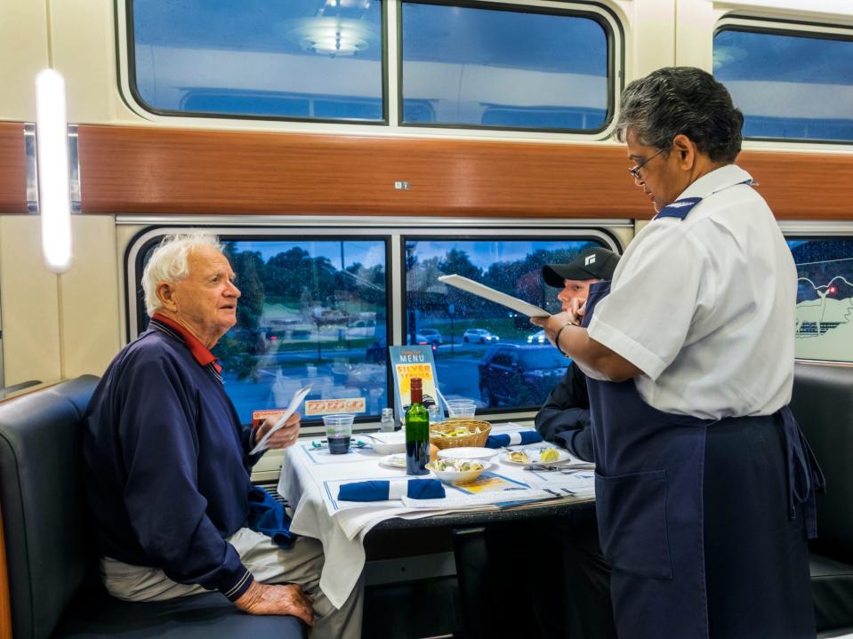 A man ordering a meal in an Amtrak dining car.