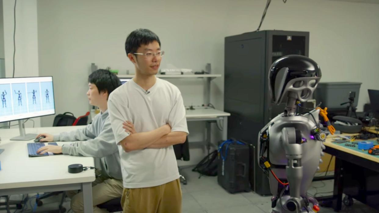  Nvidia employee next to AI robot in lab. 