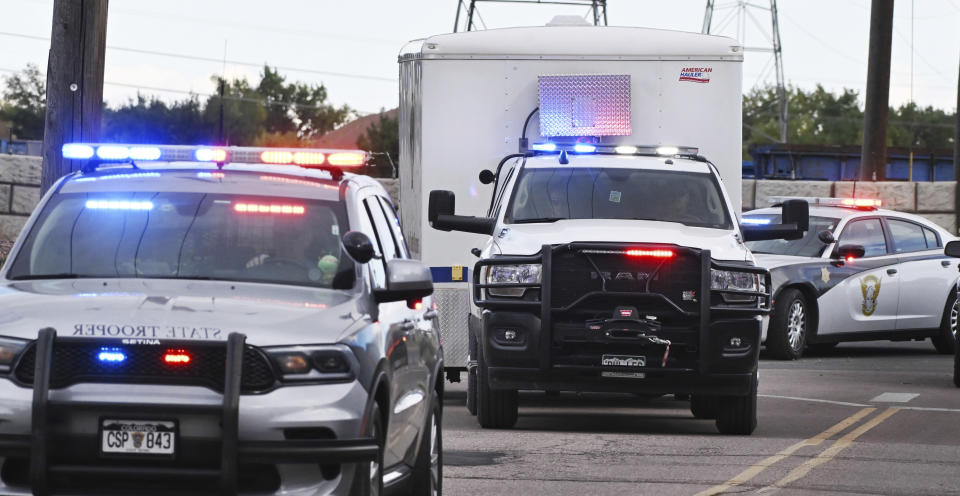 Some of the remains of the 115 decomposing bodies discovered at the Return to Nature Funeral Home in Penrose, Colo., arrive via police escort at the El Paso County Coroner's Office in Colorado Springs, Colo., Tuesday, Oct. 10, 2023. Temporary structures and refrigerated trucks filled a parking lot next to the office where they will be beginning the massive task of trying to identify the remains. (Jerilee Bennett/The Gazette via AP)