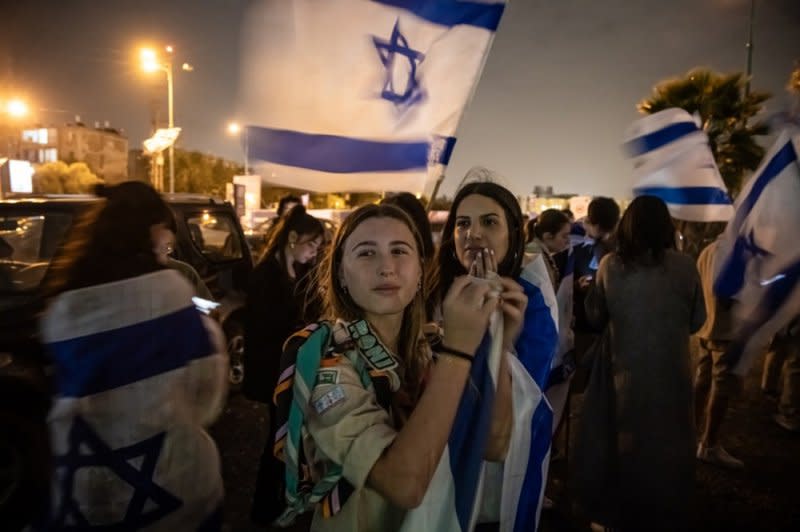 Boys and girls hold Israeli flags as they gather outside the Schneider Children's Medical Center waiting for released hostages to arrive in Tel Aviv, Israel, on Sunday. Photo by Christophe Petit Tesson/EPA-EFE
