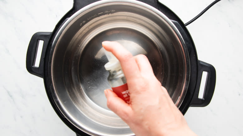 Spraying oil into slow cooker