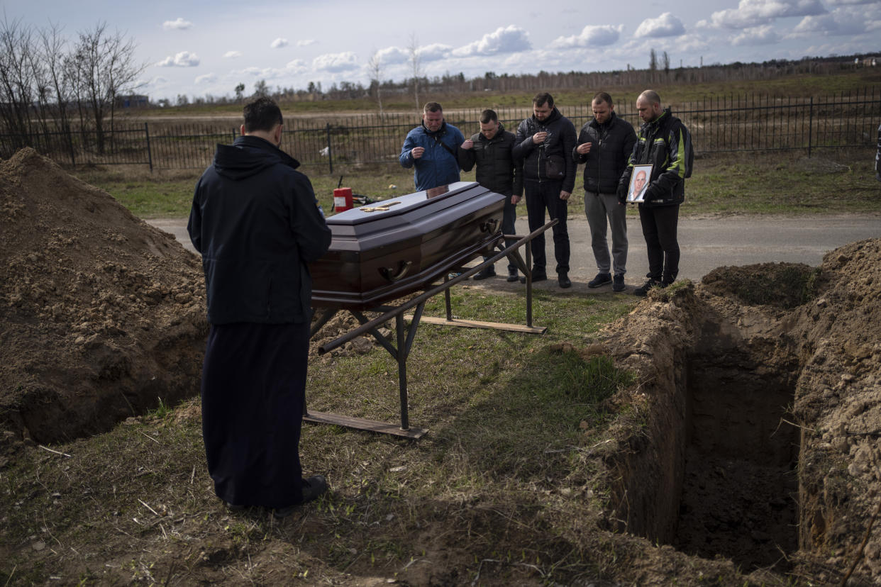 Relatives and friends attend the funeral of Andriy Matviychuk, 37, who served as territorial defense soldier, and was captured and killed by Russian army in Bucha, in the outskirts of Kyiv, Ukraine, Tuesday, April 12, 2022. (AP Photo/Rodrigo Abd)