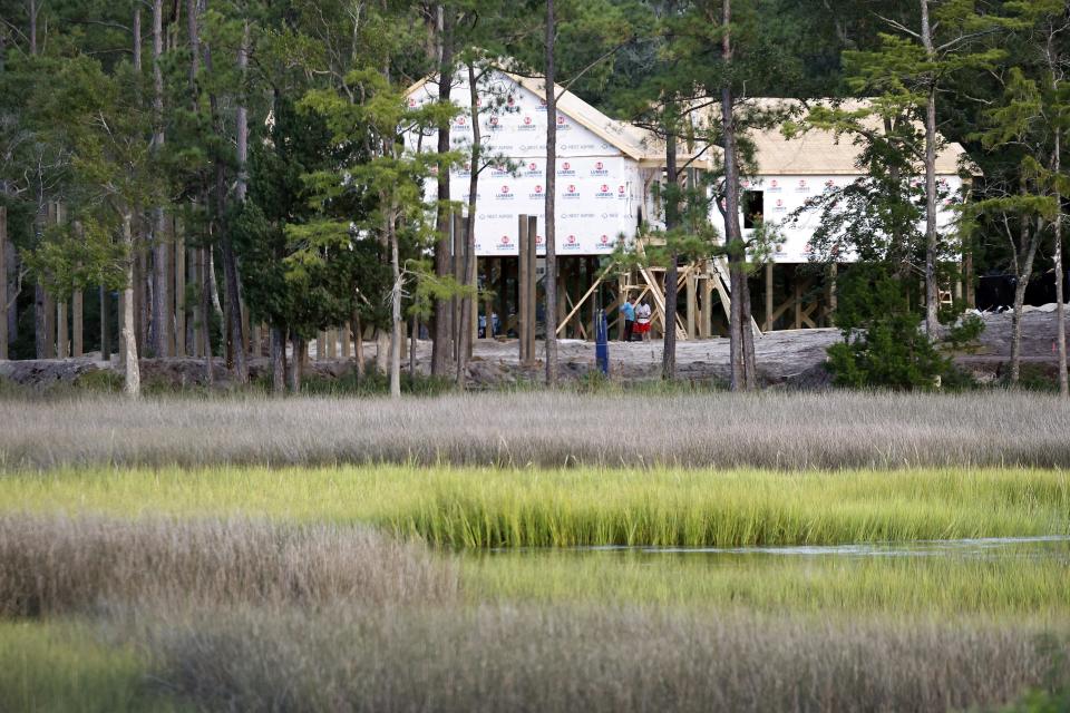 Homes are visible under construction near wetlands in Oak Island, N.C., Tuesday, Aug. 29, 2023. The Biden Administration weakened protections for wetlands on Tuesday, a win for developers and agricultural groups in some states. (AP Photo/Karl B DeBlaker)