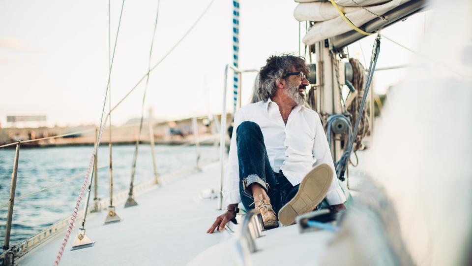 Older man resting on a yacht.
