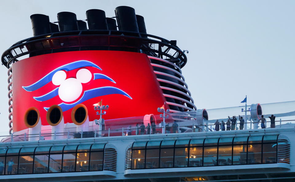 Passengers stand on the deck of Disney Dream, a Disney Cruise Lines' ship, as it sails to the Bahamas on the first Disney cruise for paying customers since they were stopped during the coronavirus disease (COVID-19) pandemic, from Port Canaveral in Florida, U.S., August 9, 2021. REUTERS/Joe Skipper