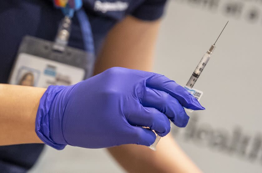 UCLA nurse Eunice Lee prepares a syringe of a Covid-19 vaccine for health care workers at Ronald Reagan UCLA Medical Center