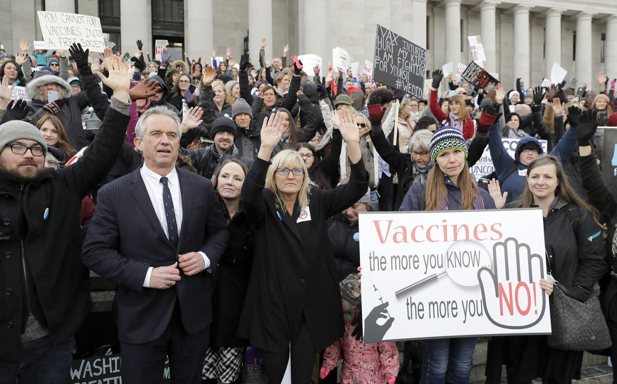 Robert Kennedy Jr., left, stands with participants at a rally held in opposition to a bill that would remove parents' ability to opt their school-age children out of the combined measles, mumps and rubella vaccine on Feb. 8, 2019, at the Capitol in Olympia, Wash. (Ted S. Warren / AP file)