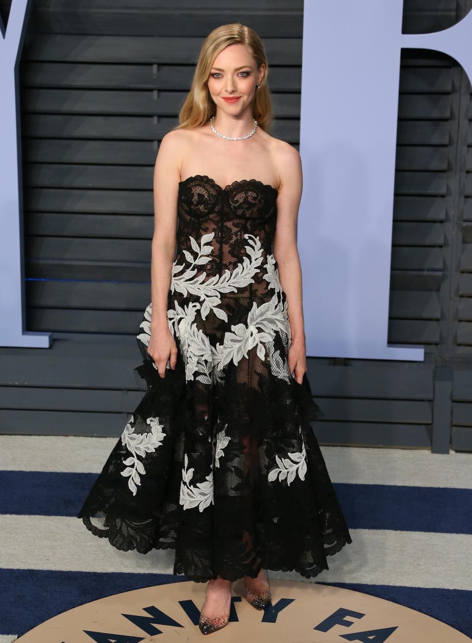 <p>Amanda Seyfried begeisterte in einem trägerlosen, aufwendig bestickten Spitzenkleid im Schwarz-Weiß-Look. (Bild: Getty Images) </p>