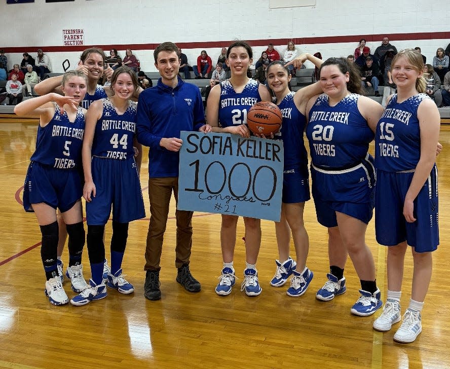 Battle Creek Academy's Sofia Keller celebrates scoring her 1,000th career point with her head coach and teammates during a win over Tekonsha in girls basketball on Tuesday.